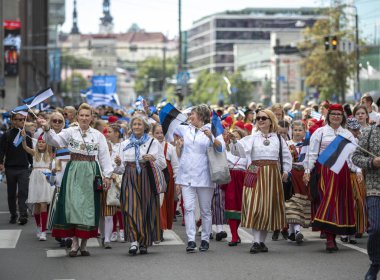 Tallinn, Estonya, 6 Temmuz 2019: Geleneksel giyimli insanlar Tallinn sokaklarında yürüyor