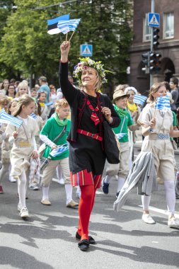 Tallinn, Estonya, 6 Temmuz 2019: Geleneksel giyimli insanlar Tallinn sokaklarında yürüyor
