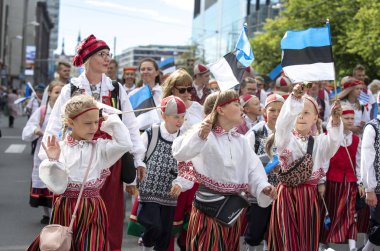 Tallinn, Estonya, 6 Temmuz 2019: Geleneksel giyimli insanlar Tallinn sokaklarında yürüyor