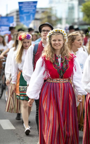 Tallinn, Estonia, 6th July, 2019: people in traditional estonian clothing in streets of Tallinn, walking to sing at song festival grounds at festival 'laulupidu'