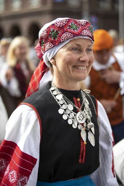 Tallinn, Estonia, 6th July, 2019: woman in traditional estonian clothing in streets of Tallinn, walking to sing at song festival grounds at festival 'laulupidu'