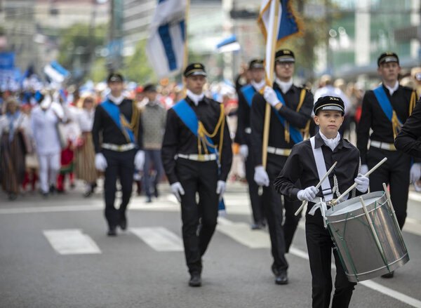 Tallinn, Estonia, 6th July, 2019: people in traditional clothing walking on streets of Tallinn