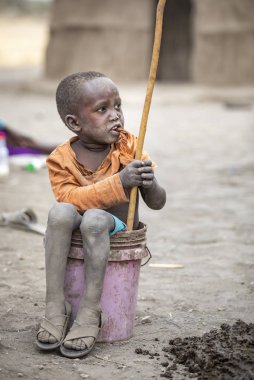 Arusha, Tanzanya, 7 Eylül 2019: Kovada oturan maasai çocuk