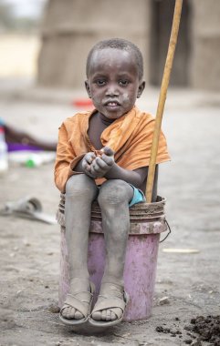 Arusha, Tanzanya, 7 Eylül 2019: Kovada oturan maasai çocuk