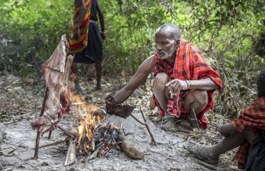 Arusha, Tanzanya, 7 Eylül 2019: Masai adam ateşte et pişiriyor