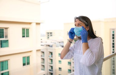 Virüs salgını sırasında orta yaşlı bir kadın maske takıyor.