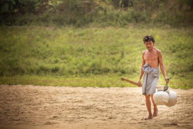 Chittagong, Bangladeş, 25 Şubat 2016: Adam içme suyu toplamak için nehre yürüyor
