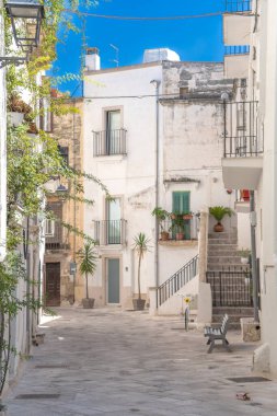 Güney İtalya 'da mavi bir gökyüzünün altındaki tarihi merkezde taş sokaklar ve Akdeniz balkonları arasında binaların bir görüntüsü. Grottaglie bir seramik şehridir..