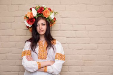 Nakışlı gömlekli ve başında çelenk olan bir kızın portresi. Çelenk geleneksel ukraynalı kız başlığıdır. Nakışlı gömlek - geleneksel Ukrayna giysileri.