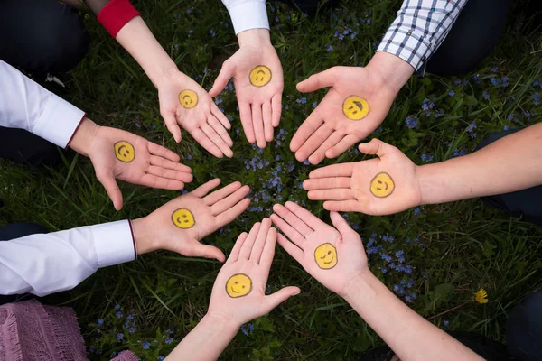 International Friends Day. Happy international friendship day. Top view of eight friends hands. The palms are turned upwards. Smilies are painted on the palms. Right hand