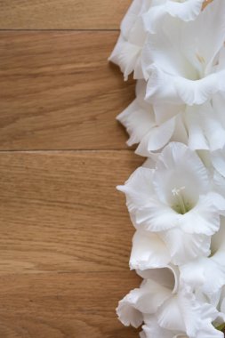 Beyaz gladioli dokulu ahşap yüzey üzerinde yalan. Altyazılar için boş alana sahip bir tarafı. Düğün veya tatil tebrik için tebrik kartı. Üstte görüntü