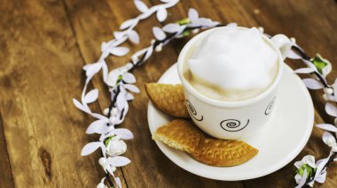 Kahve beyaz çiçek taç tarafından çevrili bir ahşap tablo.