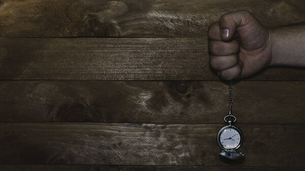 Pocket watch with chain with wooden background