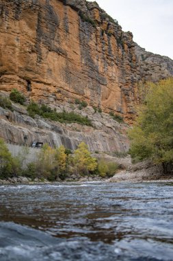 Cliff peyzaj taş Kızıl tonları ile bir Nehri üzerinde.