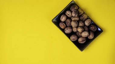 Siyah düz tabak sarı bir arka plan üzerinde deli dolu.