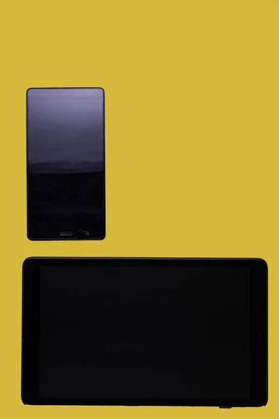 Czarny Tablet Smartfon Żółtym Tle Pozostawiając Powietrze Prawej Stronie Obrazu — Zdjęcie stockowe