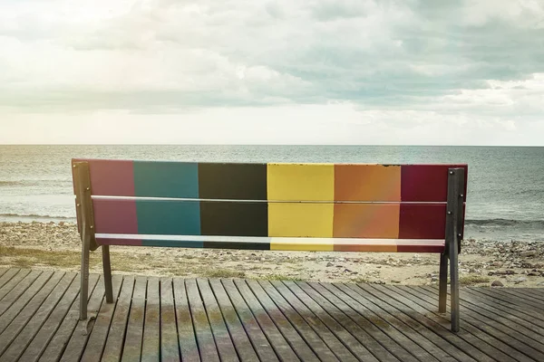 Bandeira de orgulho LGBT arco-íris pintada em um banco de madeira . — Fotografia de Stock