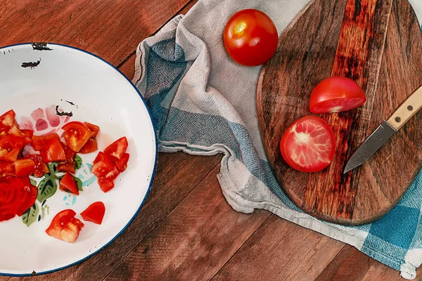 Tomates en rodajas en un plato de hojalata sobre una mesa de madera . — Foto de Stock
