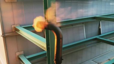 Gün doğumunda metal bir borudan çıkan su buharı.