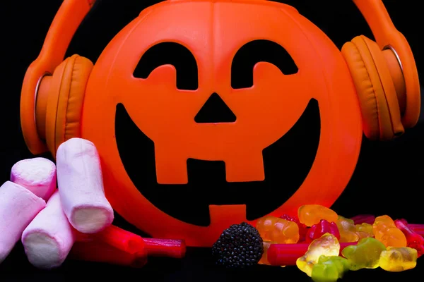 Zucca di Halloween con cuffie arancioni e sfondo nero . — Foto Stock