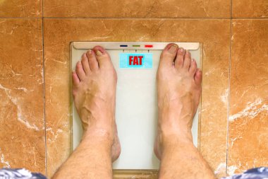 Kilolu adam bir ölçekte kendini ağırlığında.