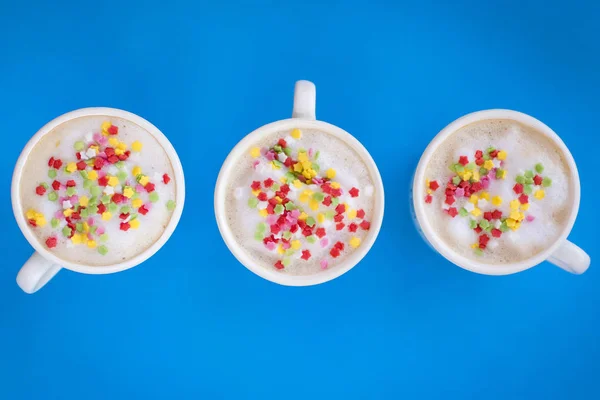 Party decorated coffee cups with foam and colored stars.