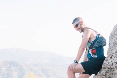 Erkek dağ koşucusu koştuktan sonra dinleniyor.