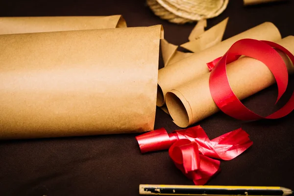 Utensils for wrapping Christmas gifts such as scissors, red ribbon or string.