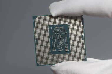 Beyaz eldiven bir Cpu bilgisayar işlemci mikroçip gri üzerine tutarak el
