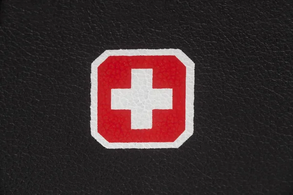 生地の黒革の質感にスイスの国旗を背景を閉じる — ストック写真