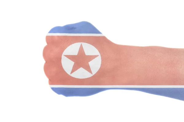 北朝鲜的旗子在男性手用握紧的拳头隔绝在白色背景上 — 图库照片