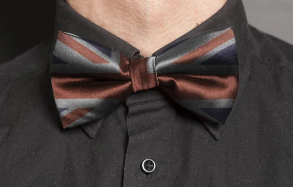 Man Dressed Black Shirt With Black Bow Tie with British flag closeup