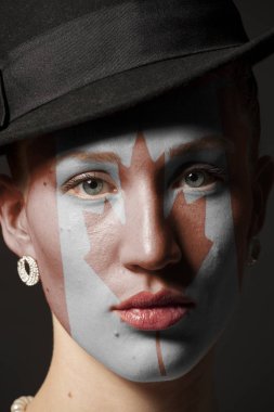 Kadın yüzü boyalı Kanada bayrağı portre siyah arka plan üzerine