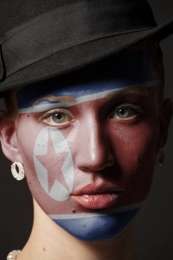 Kadın yüzü boyalı Kuzey Kore bayrağı portre siyah arka plan üzerine