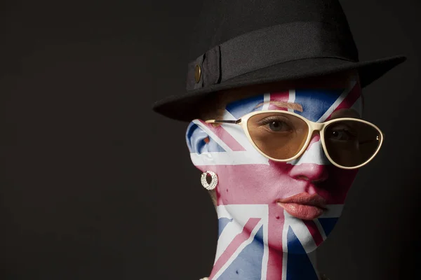 イギリス国旗を塗りと黒の背景にサングラスの女性の肖像画 — ストック写真