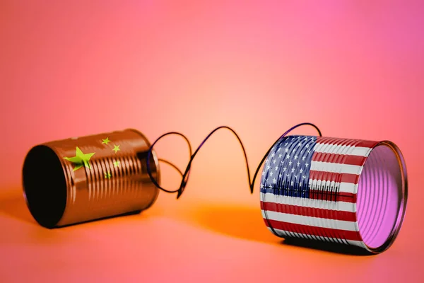 ピンクの米国および中国の Flags Communication の概念とブリキ缶電話 — ストック写真