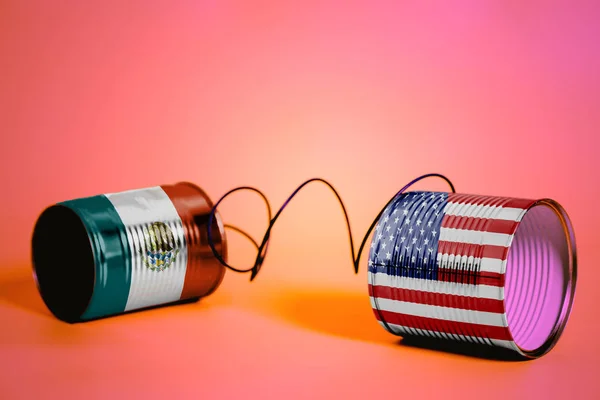 ピンクのアメリカとメキシコの Flags Communication の概念とブリキ缶電話 — ストック写真