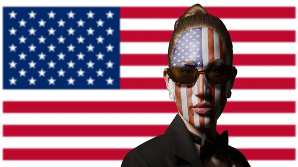 Portrait of woman with painted USA flag and sunglasses on usa background