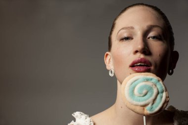 Portre güzellik gri arka plan üzerinde renkli lolipop tutan kadın