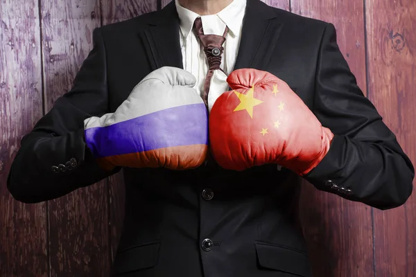 Boks eldivenleri Rus ve Çin bayrağı ile işadamı. Rusya Çin kavramı karşı. — Stok fotoğraf