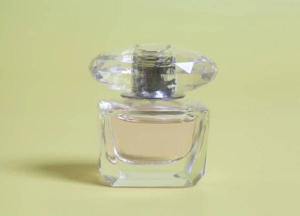 黄色の背景の上にボトルで女性香水 — ストック写真