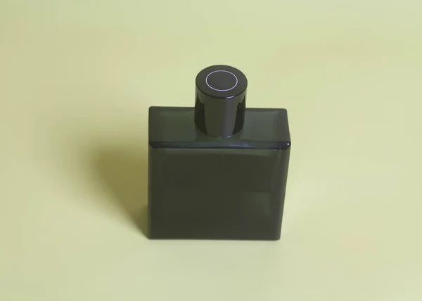 men's perfume in bottle on yellow background