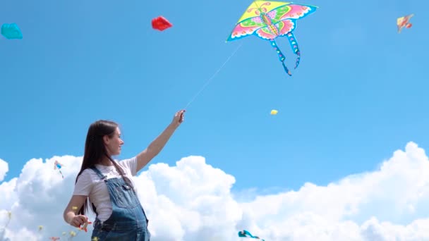 A, young, pregnant, girl, jumpsuit, launches, kite, against, blue, sky, clouds. — Stock Video