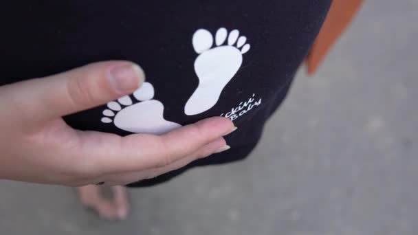 Όμορφο κορίτσι έγκυος σε ένα T-shirt χαϊδεύοντας την κοιλιά της σε αναμονή για το μωρό — Αρχείο Βίντεο