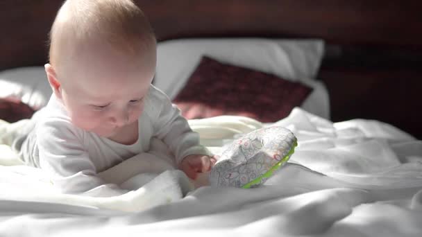 Χαριτωμένο μικρό μωρό αγόρι, χαλαρώνοντας και παίζοντας στο κρεβάτι, χαμογελώντας Ευτυχώς, τη διάρκεια της ημέρας — Αρχείο Βίντεο