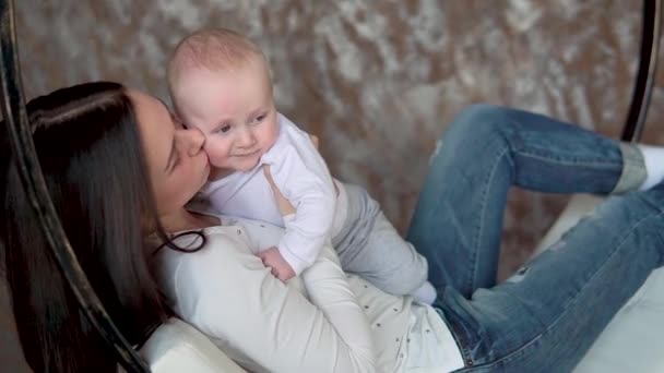 Gelukkig moeder en Baby zoenen en knuffelen, moederschap concept moederschap mooie Happy Family op een schommel — Stockvideo