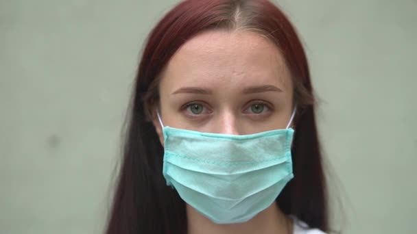 Young woman puts on glasses before surgery. Quarantine, epidemic. tired smile. Covid-19 — Stock Video