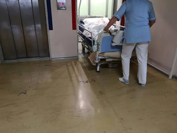 nurse carries patient on stretcher with lift