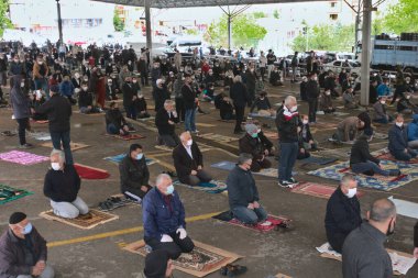 Mesafeli Müslüman erkekler, Türkiye 'de 3 ay karantina altında kaldıktan sonra jumah namazında oturuyorlar