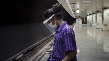 Uzun saçlı, soyutlanmış ve zeki bir genç metroya yalnız binmeyi beklerken telefonuyla oynuyor.